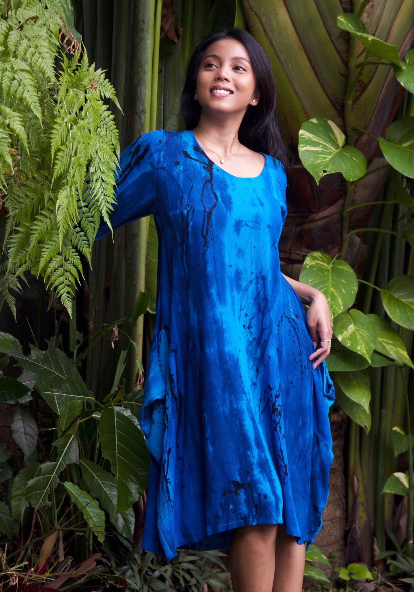 Woman in blue handpainted batik dress with a jungle background