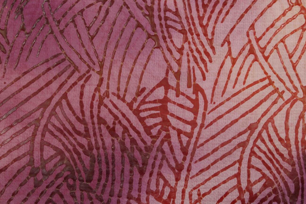 Fabric in lighter red nuances. The third step in the batik making process is bleaching the fabric so the color is bleached int eh areas not covered with wax. 