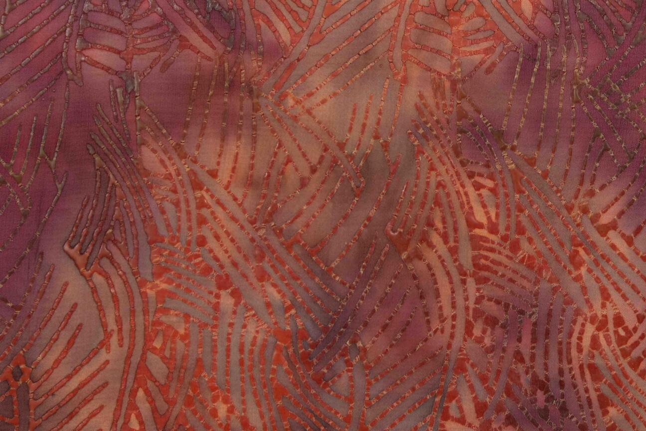 Fabric with new red nuances. The fourth step in the batik coloring process is to redye tha fabric with new red colors. The fabric will soak the colors in the places that dont contain wax